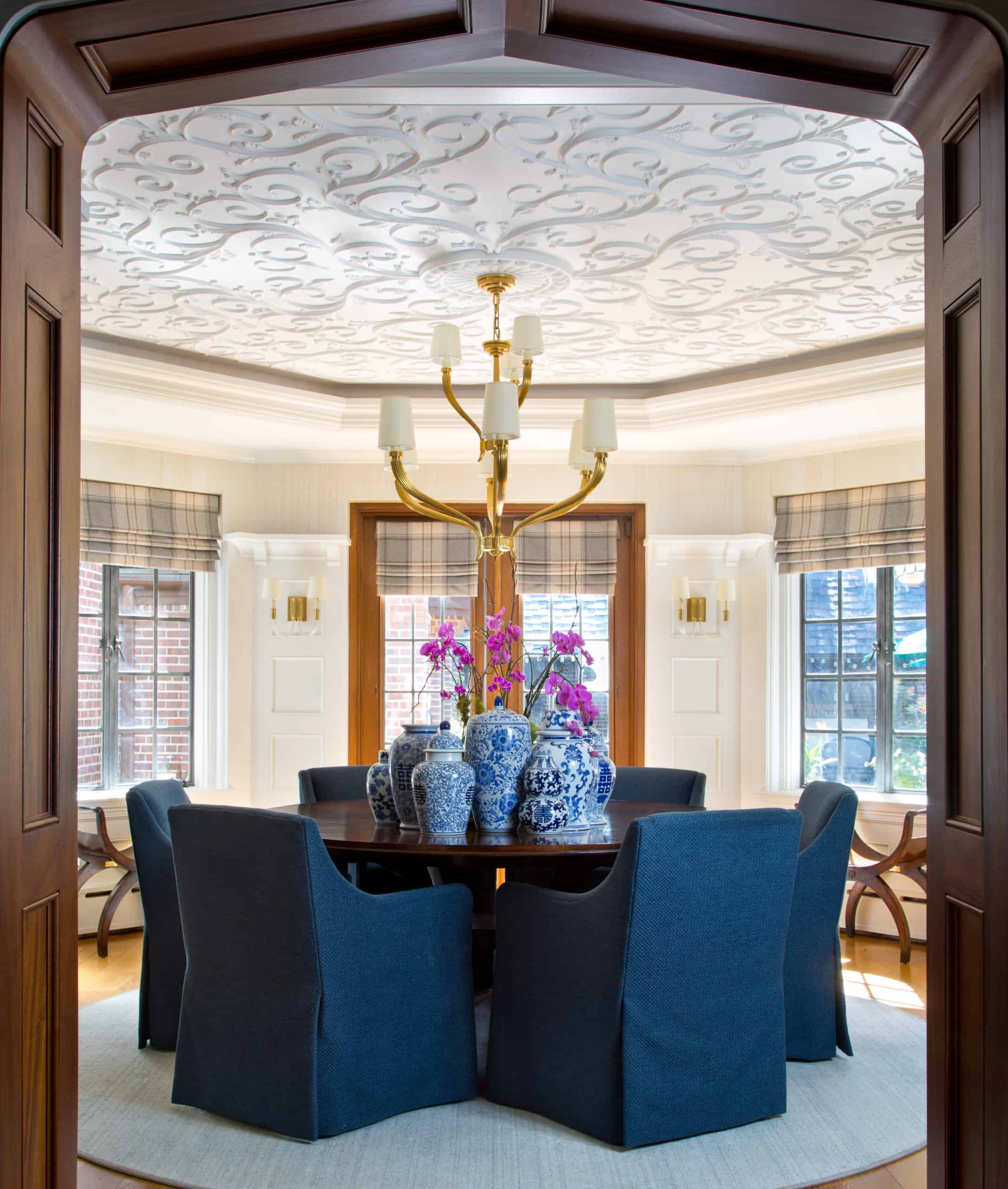 Mixing old and new decor in interior design with a gorgeous 2-tier dining room chandelier and reupholstered arm chairs