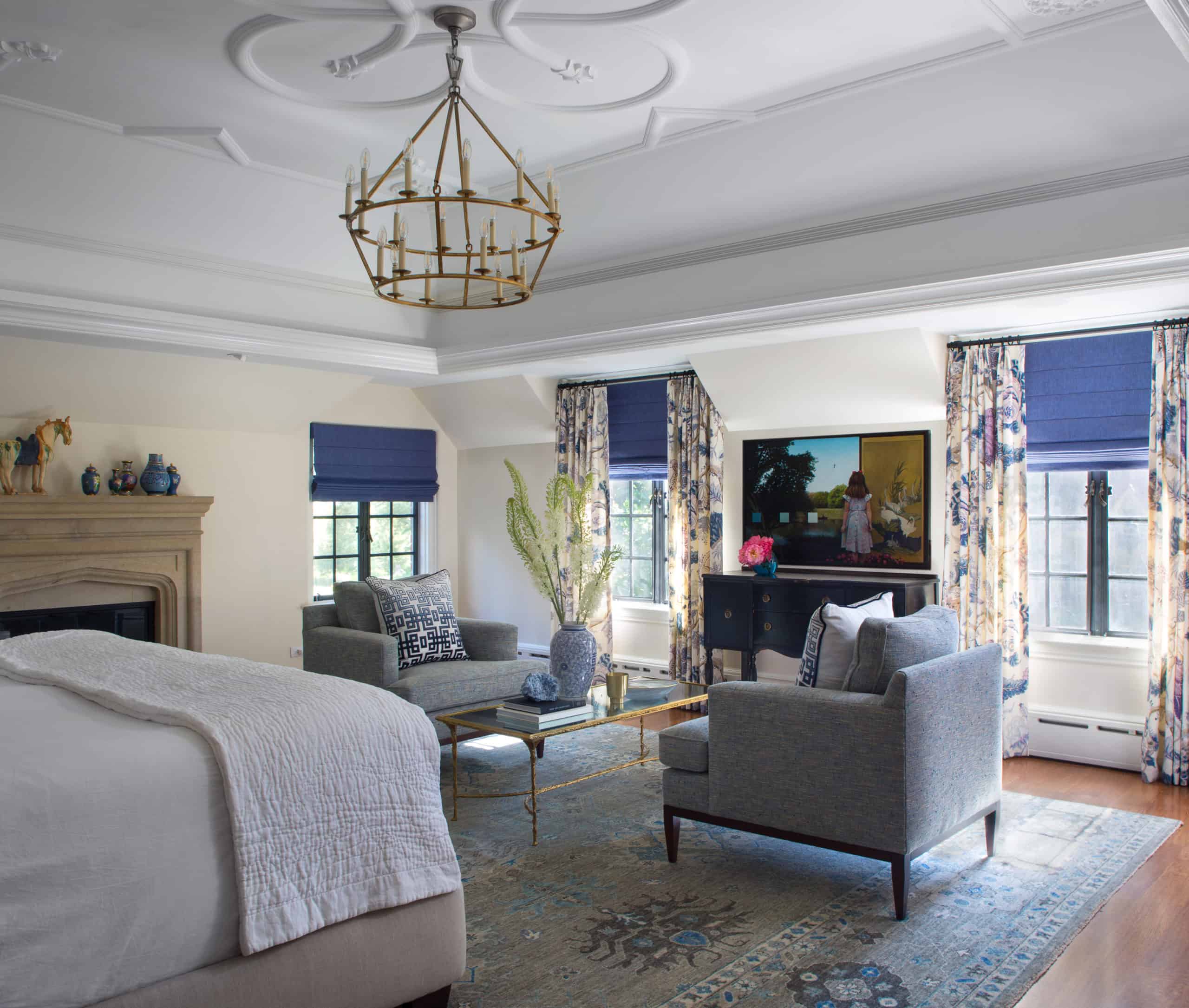 Gilded Iron 2-Tier Chandelier and Luxe Brass and Mirror Cocktail Table in Master Sitting Area with Decorative Ceiling