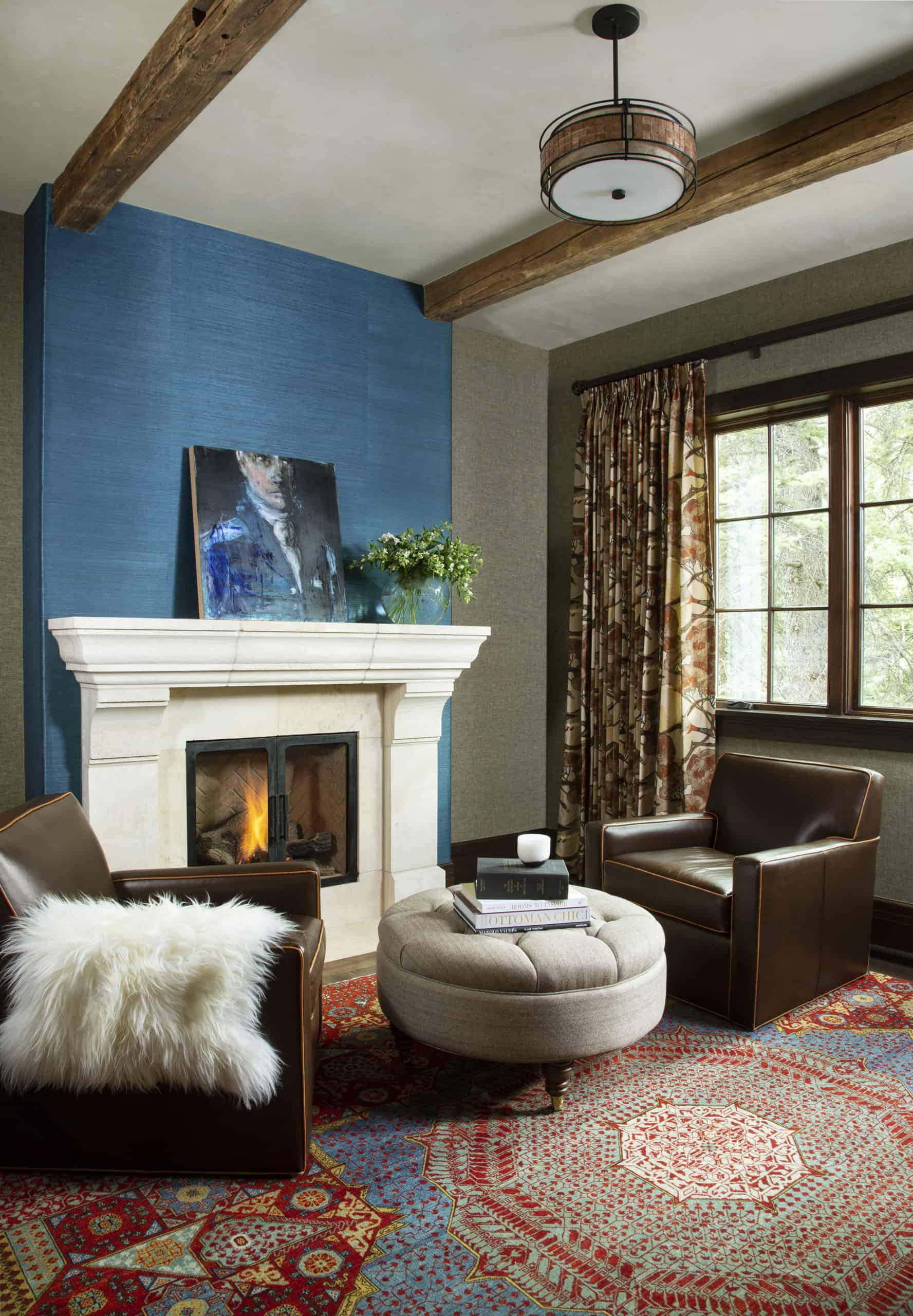 Stylish sitting room with wallpapered fireplace chimney and beamed ceiling by Andrea Schumacher Interior Design
