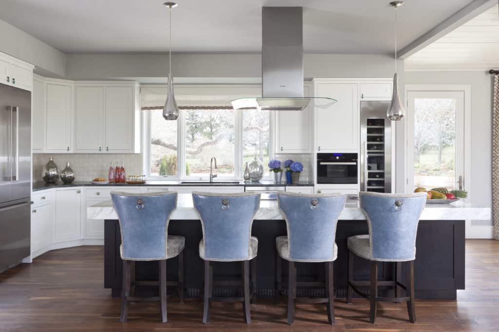 Large, thick kitchen island with custom stools with blue leather, fabric and head to head nailheads