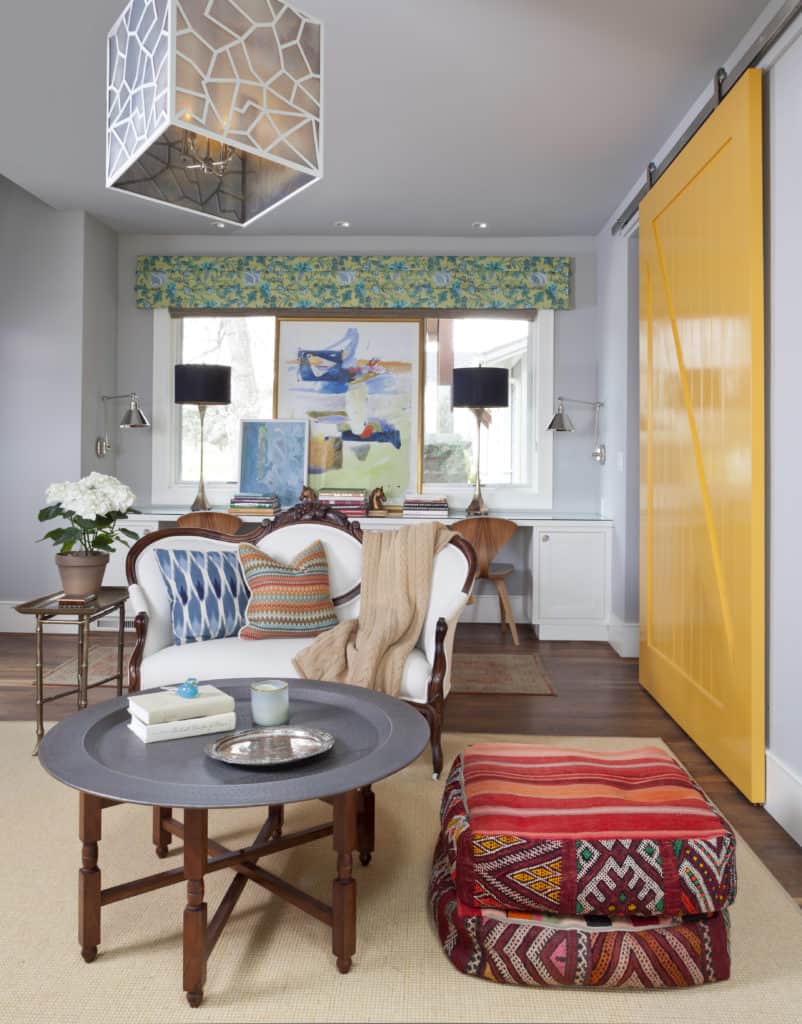 Colorful sitting room mixes old and new decor with bright yellow barn door