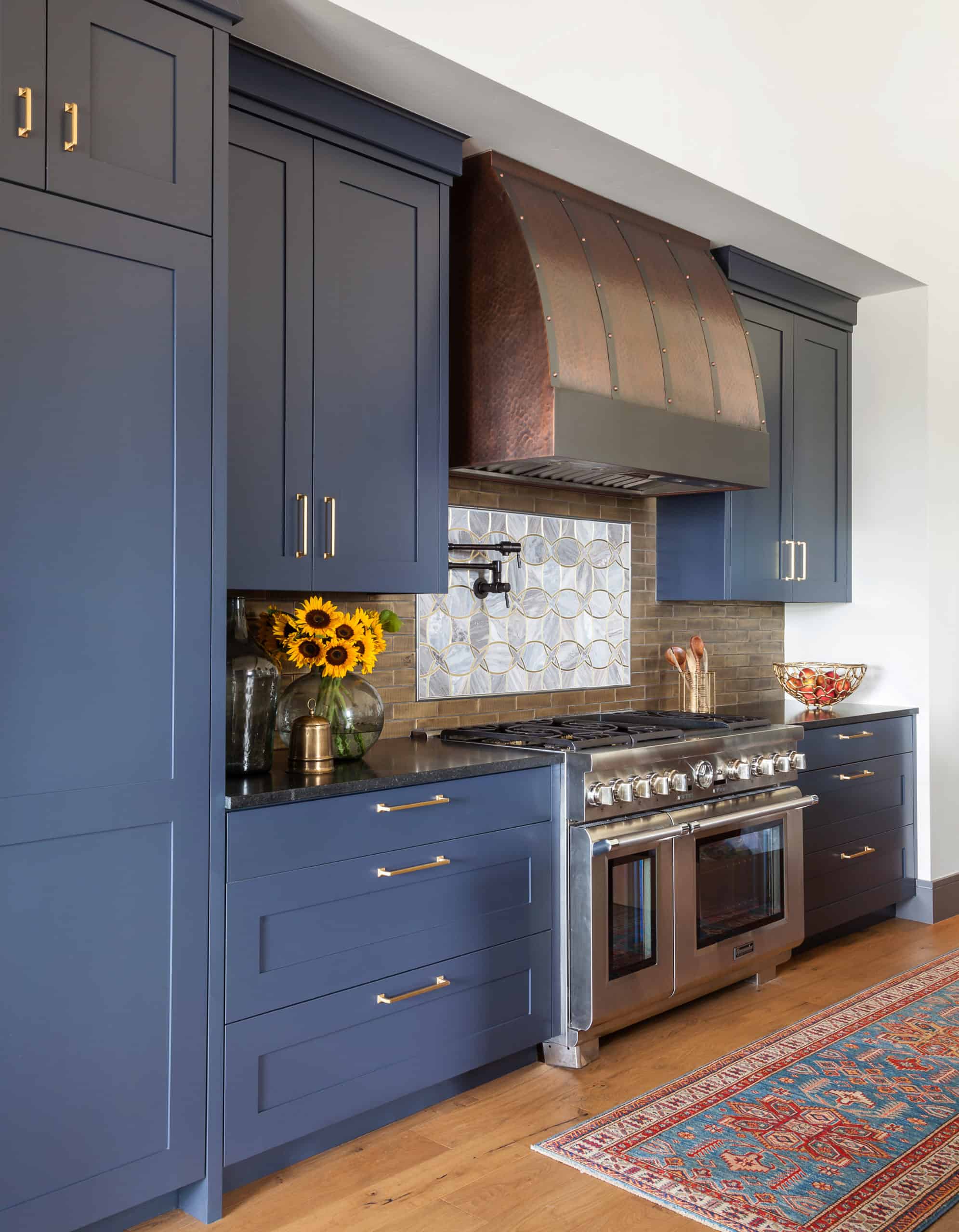 Blue kitchen cabinets copper hood in upscale kitchen