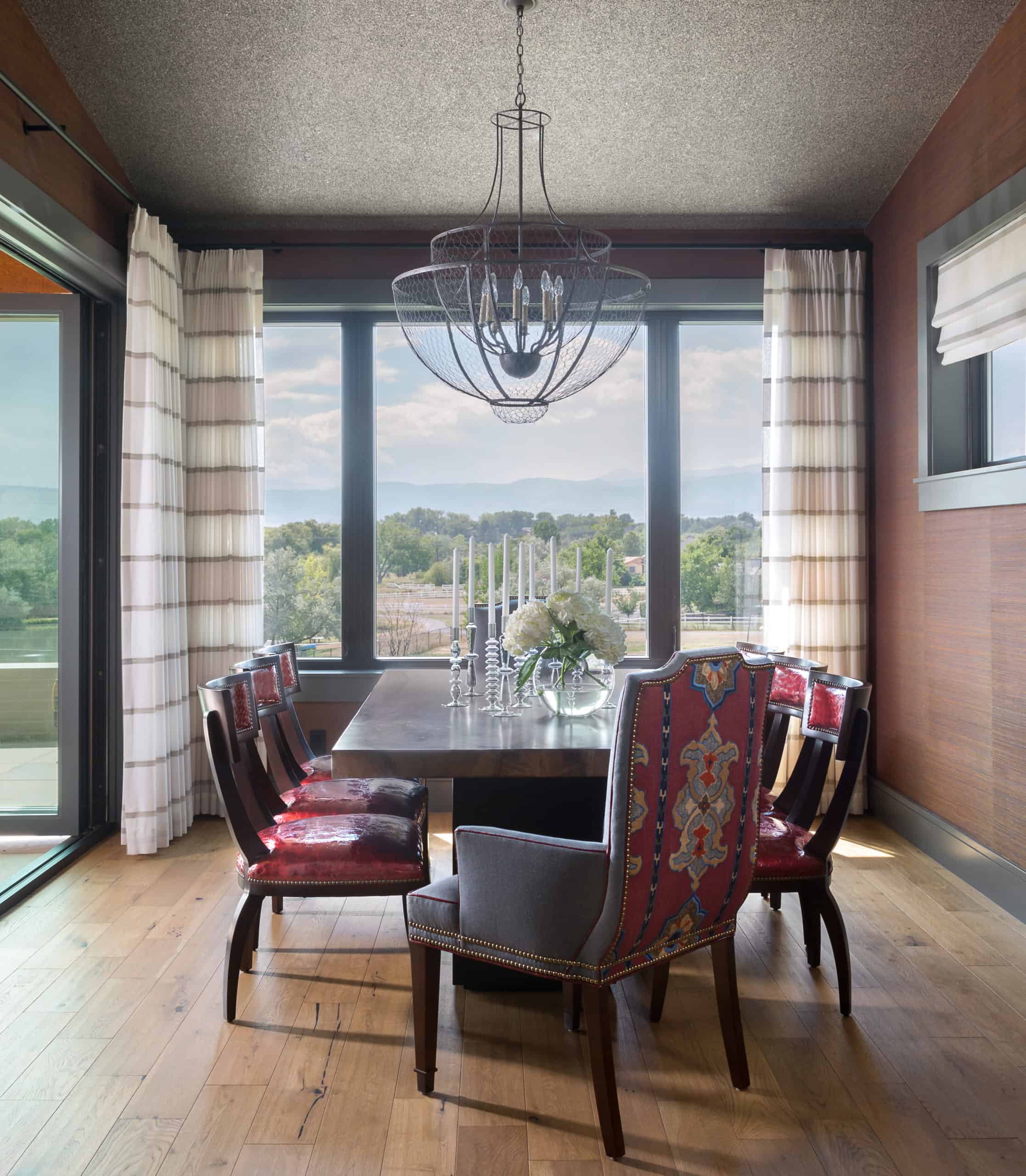 Dining room with block-style pedestal base table and patterned fabric dining chairs colorado style