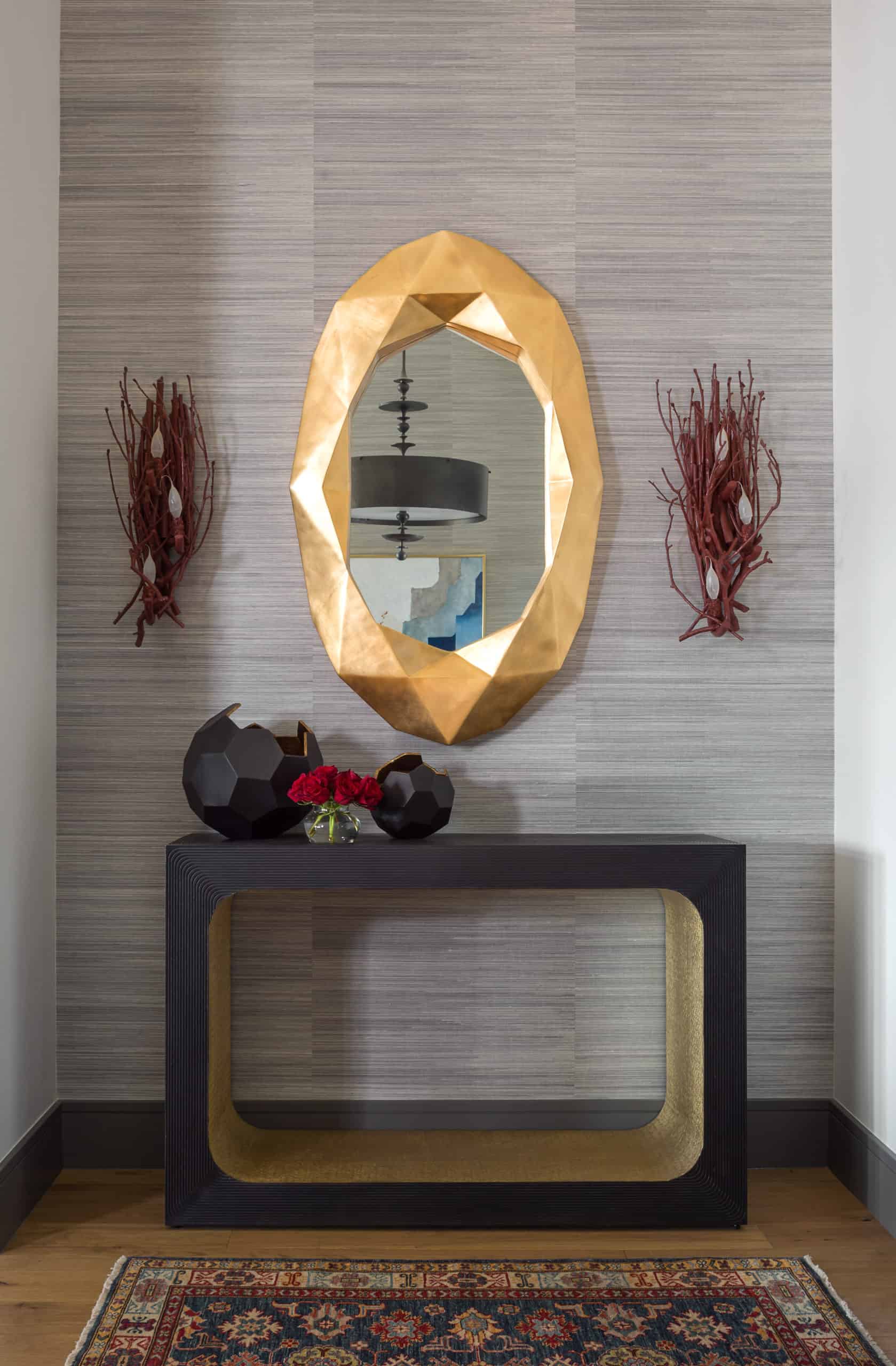 Entry with grasscloth wallpaper, black console and gold leaf geometric mirror