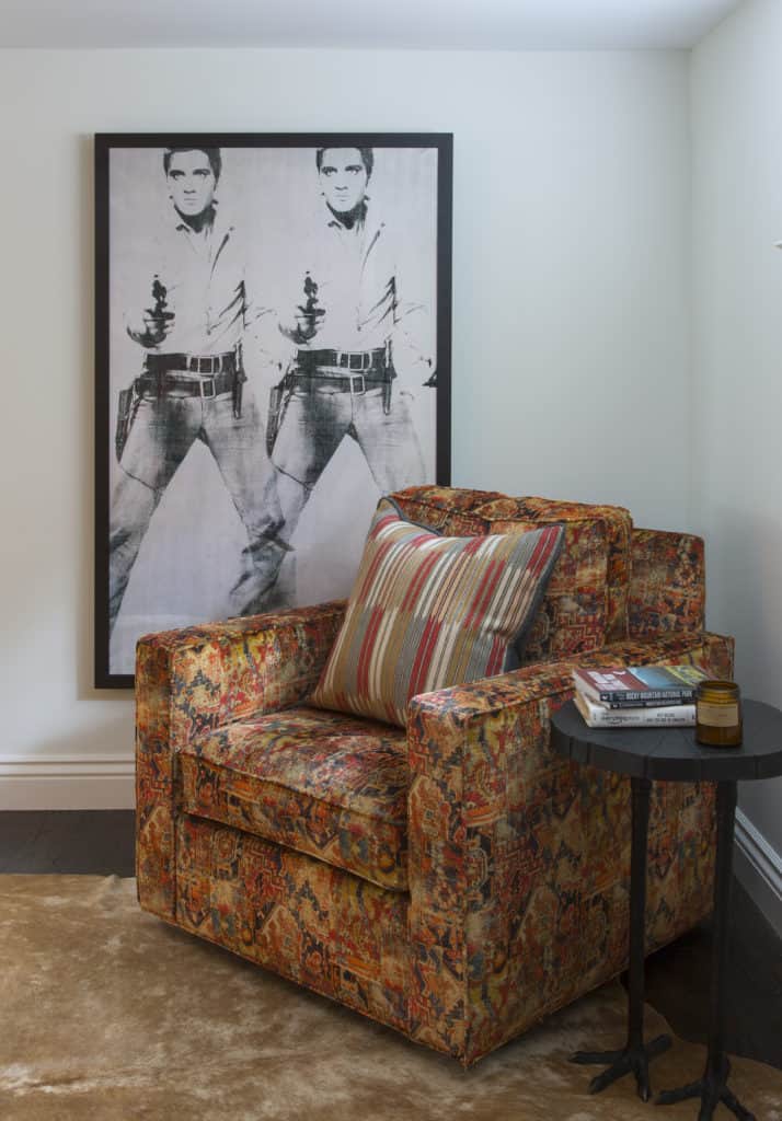 Orange print fabric on custom chair, bird leg side table and Elvis print