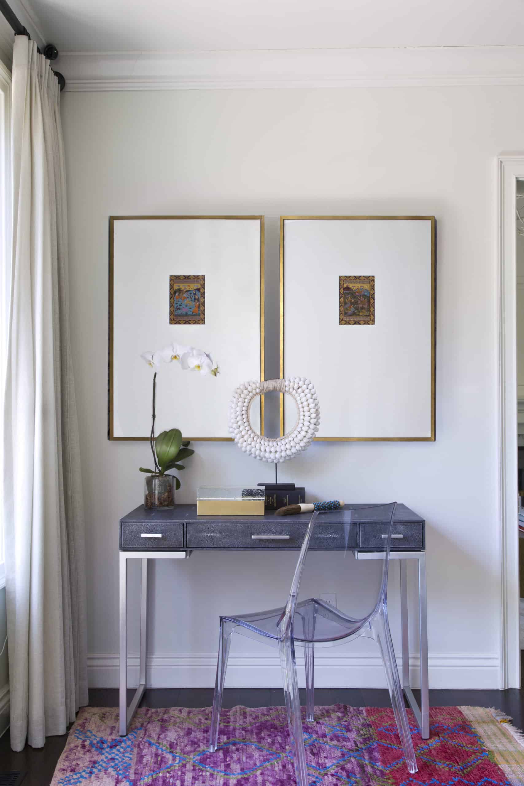 Modern desk with clear chair and curated artwork
