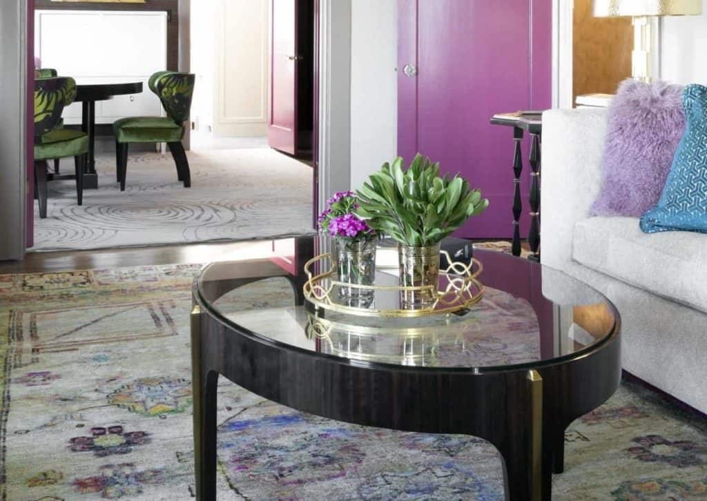 Glass top coffee tables, gold lamps, and splashes of color in home interiors
