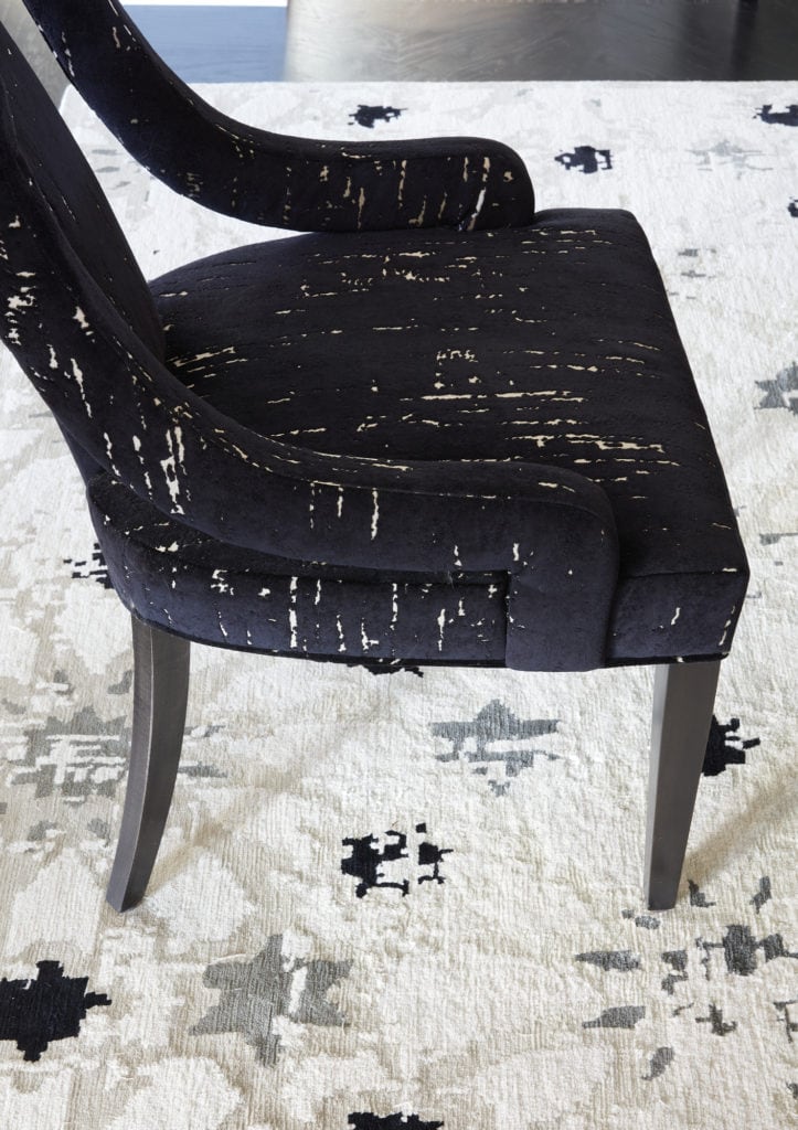 Black accent chair with patterned white area rug