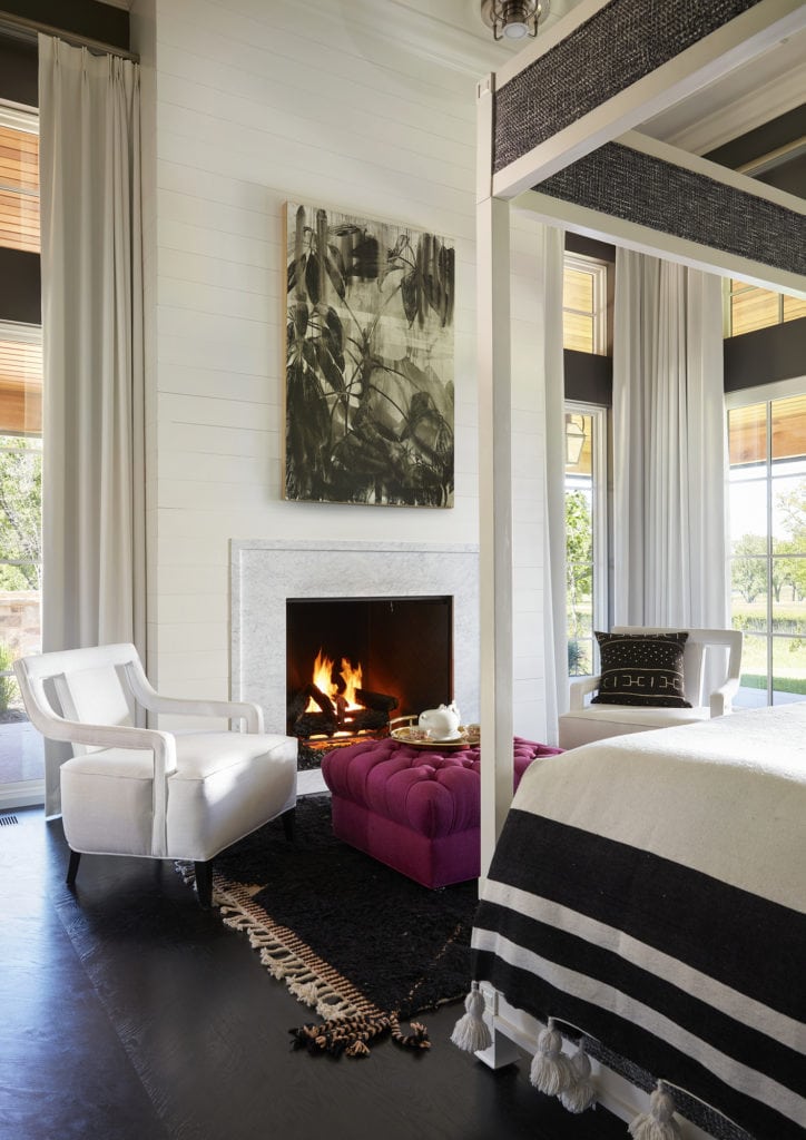 Luxury serene master bedroom with a fireplace and pops of color