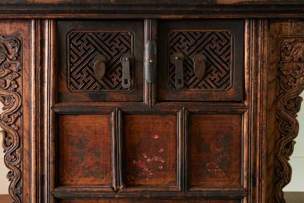 antique carved entry chest in modern lake house