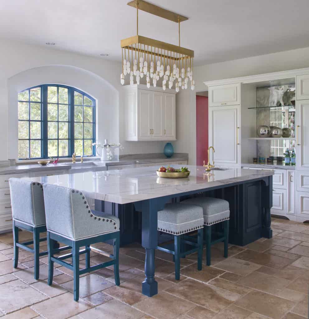 Custom kitchen with huge island and unique chandelier by Vibrant Interior Designers