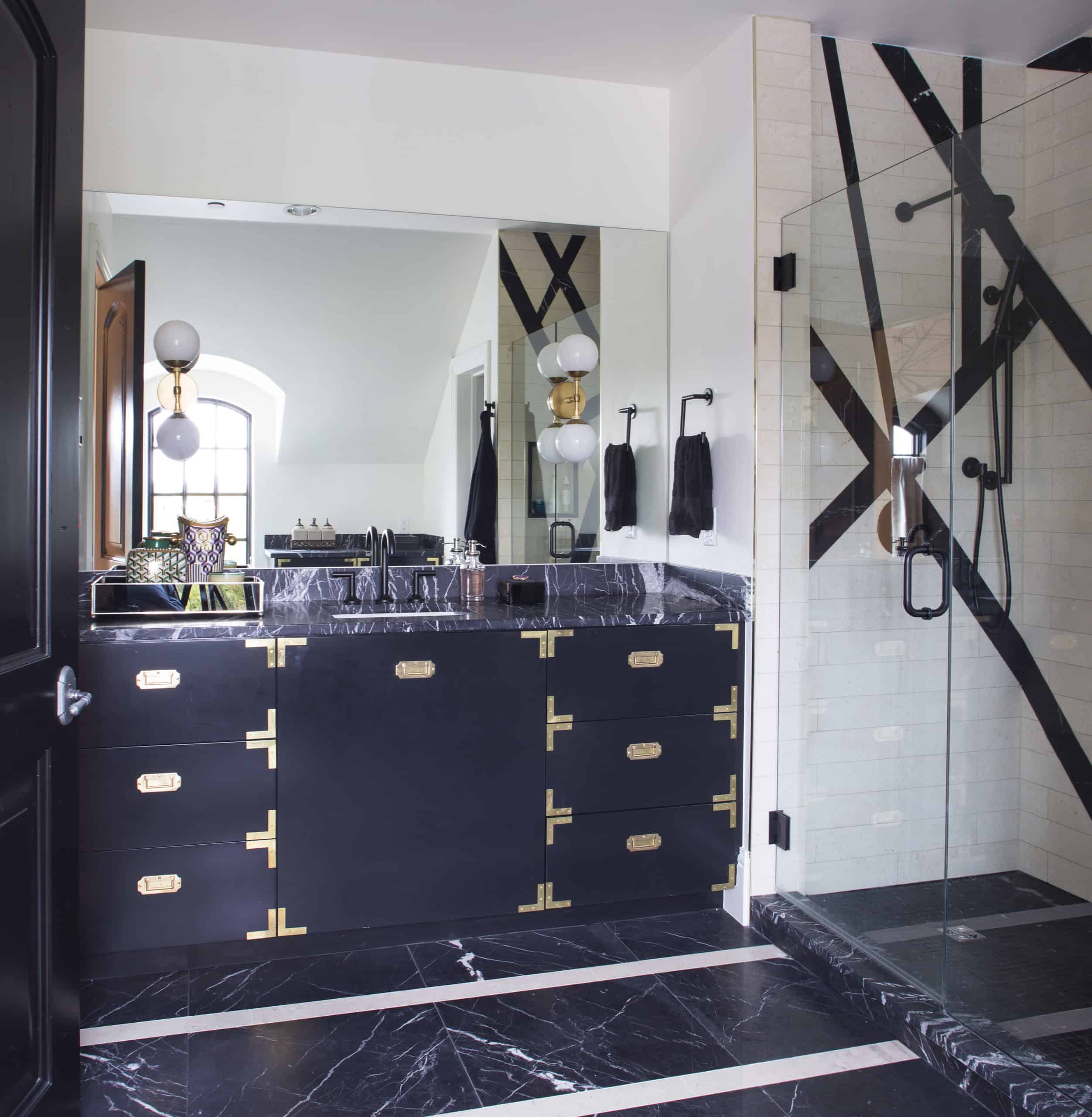 Contemporary masculine bathroom design in black and white with gold accents