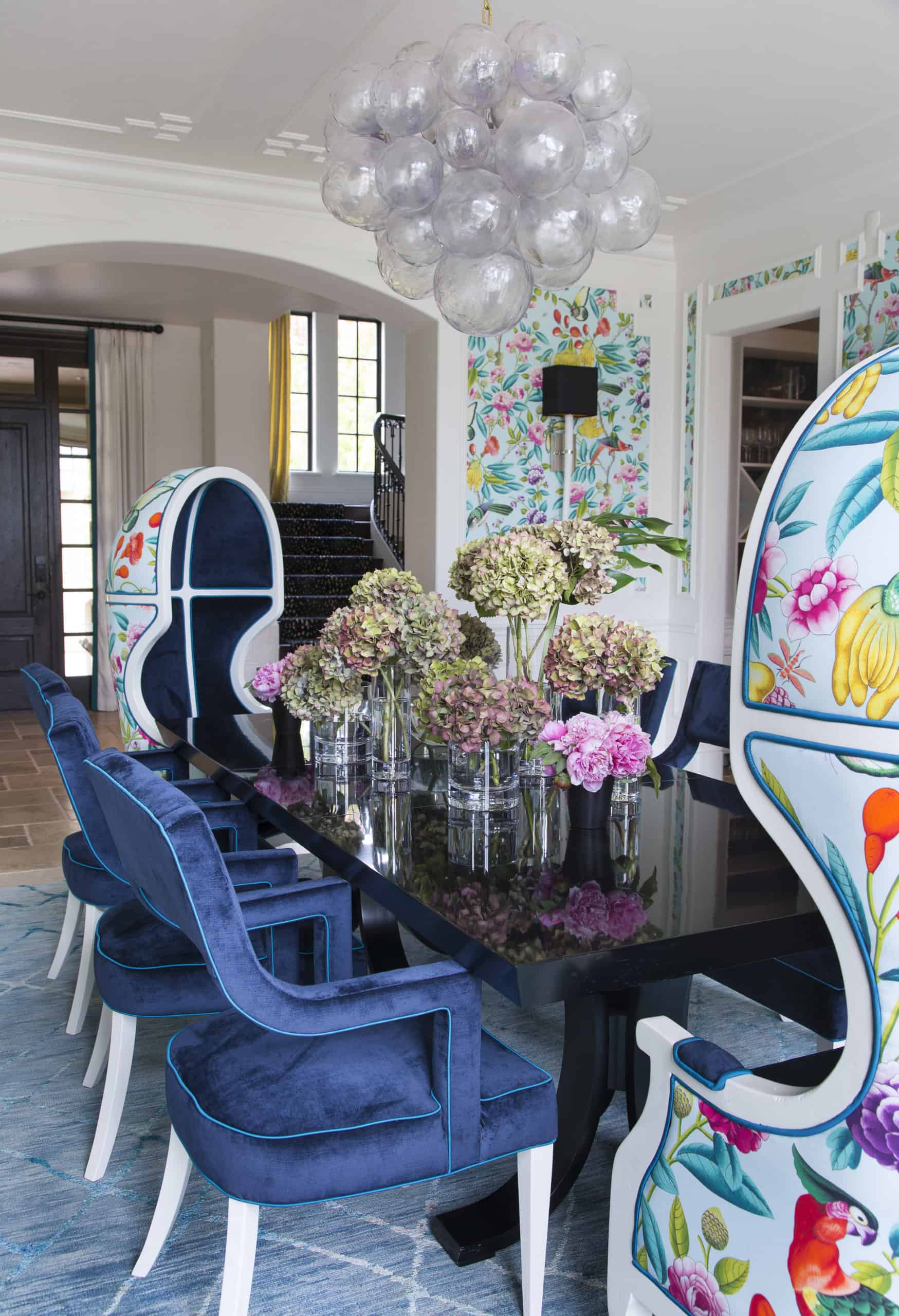 Bubble chandelier over whimsical dining space with colorful wallpaper