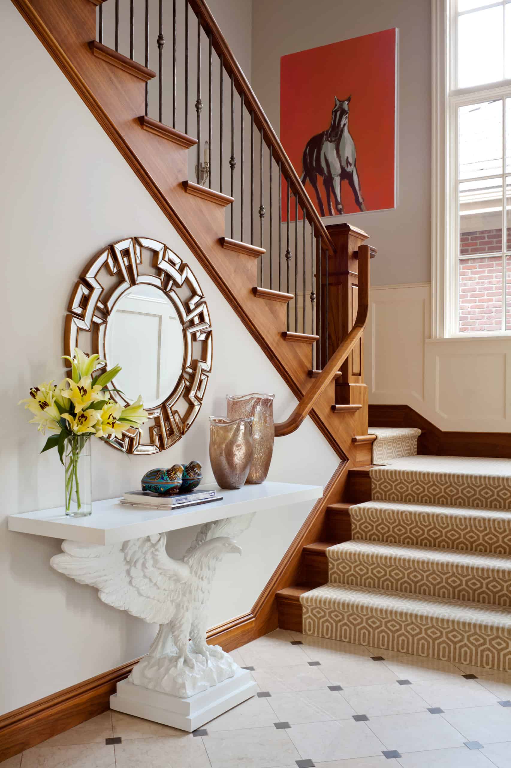 Simple foyer with eagle console table and wooden banister