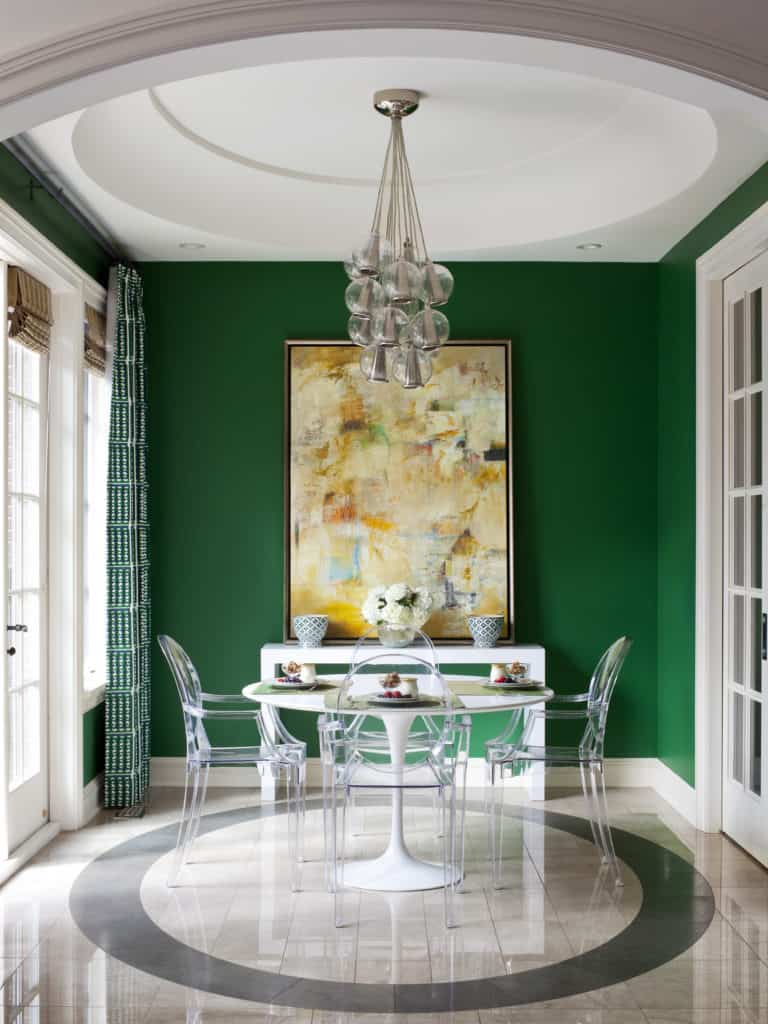 Elegant breakfast room with large artwork, multi globe glass chandelier and clear dining chairs