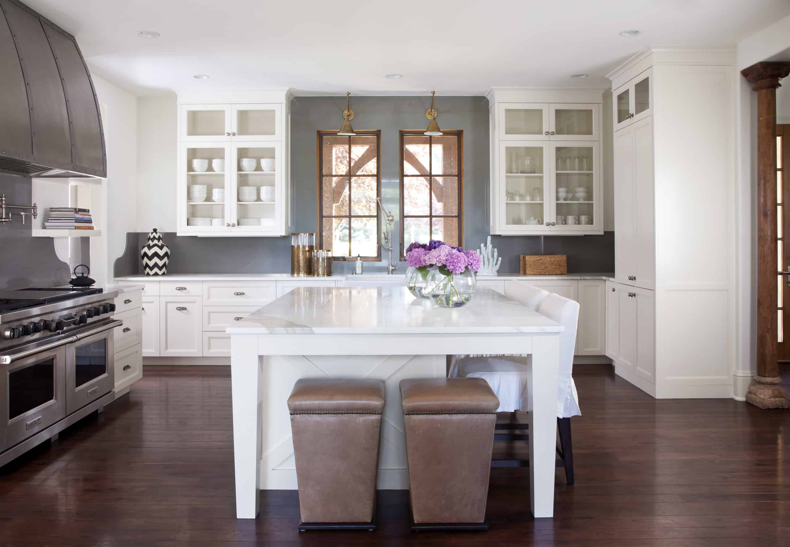 Remodeled Denver kitchen with huge white island and metal stove hood