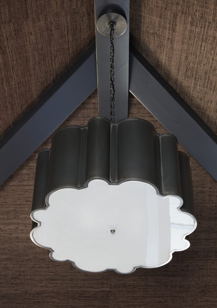 unique pendant light on wallpapered vaulted ceilings