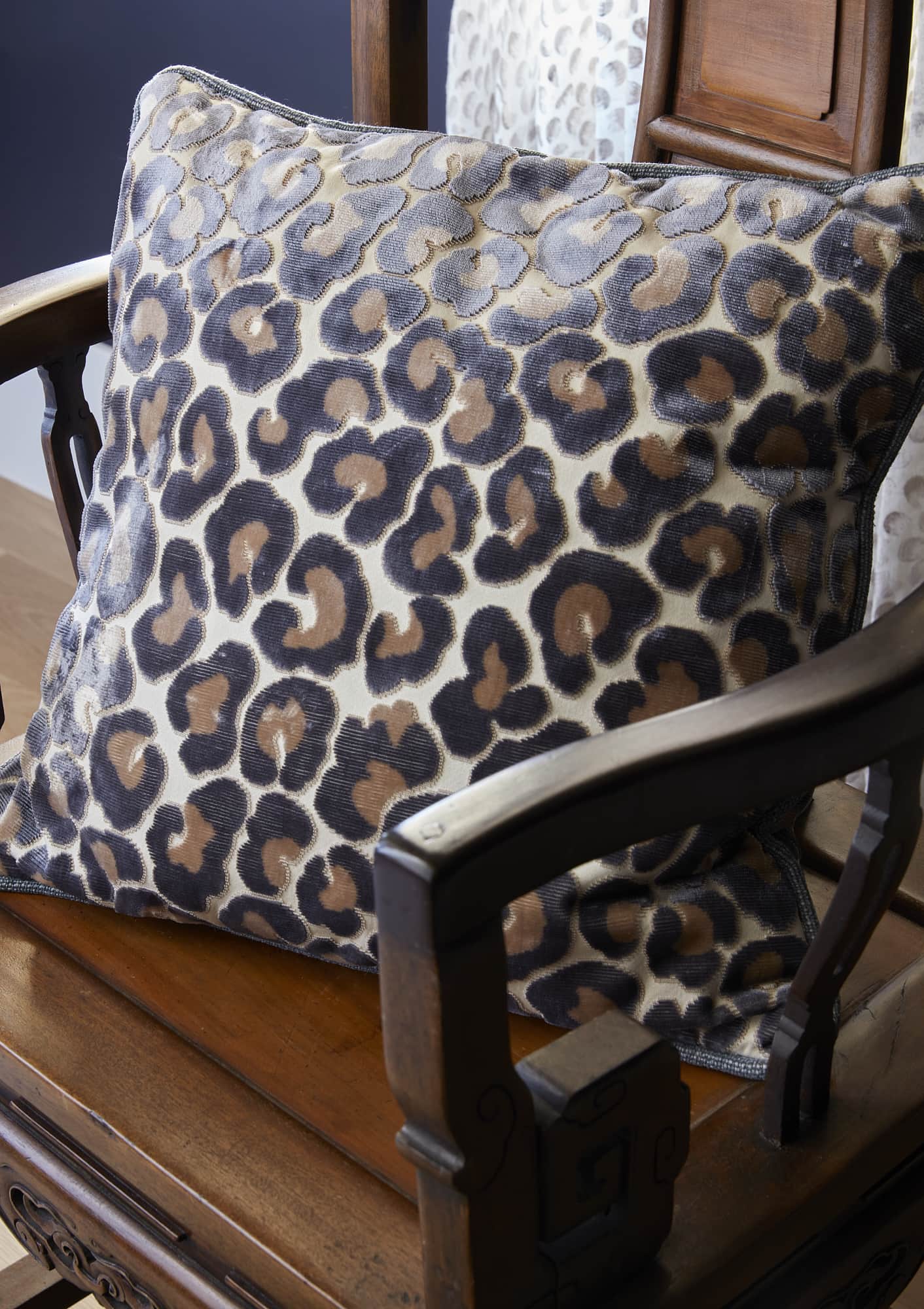 velvet animal print throw pillow on antique wooden chair