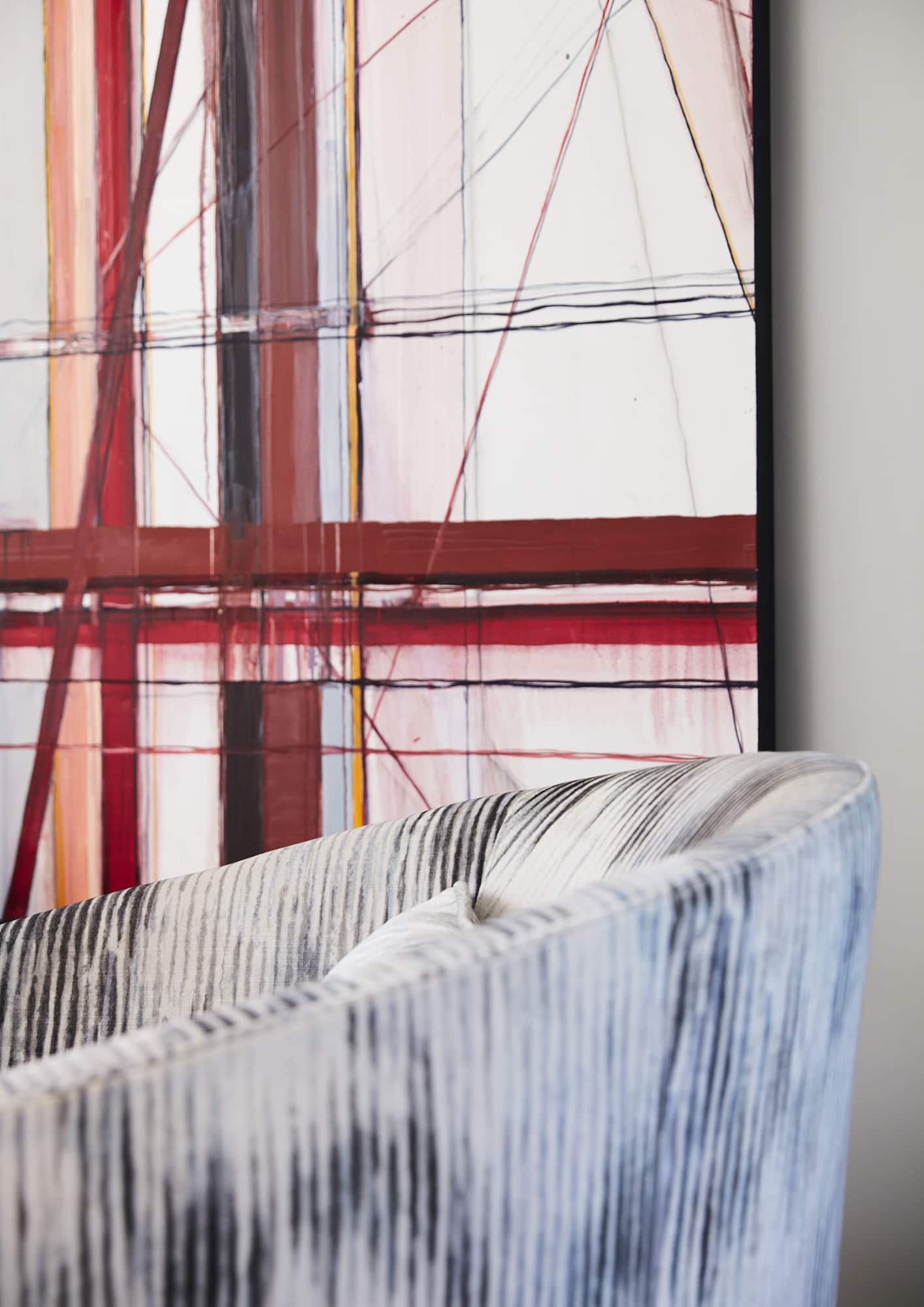 black and white upholstered chair and linear modern art