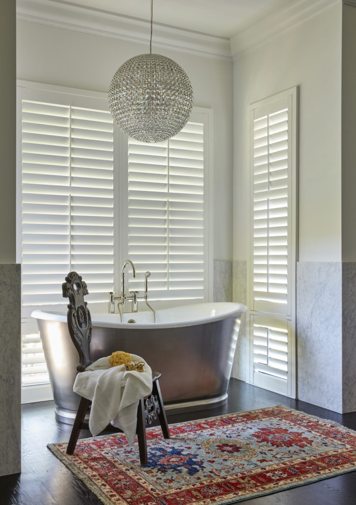 white bathroom with a standing bathtub and antique rug by denver interior design firm