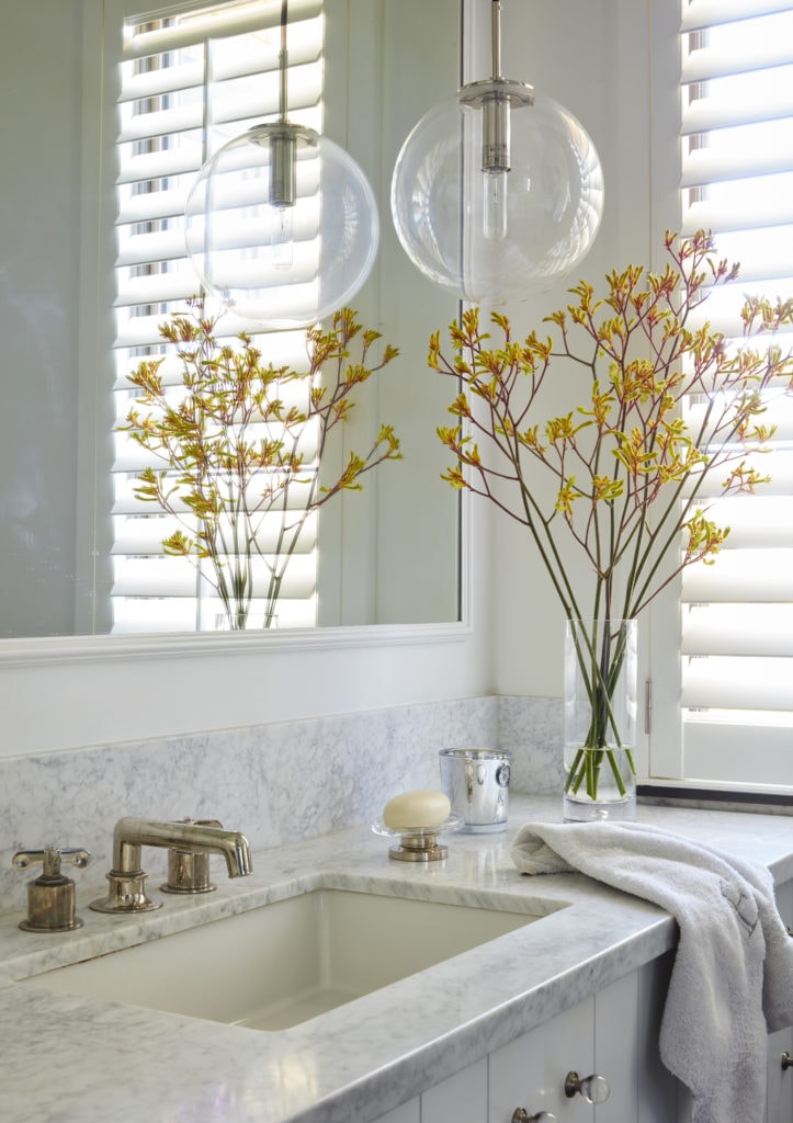 white bathroom with marble countertops and natural light
