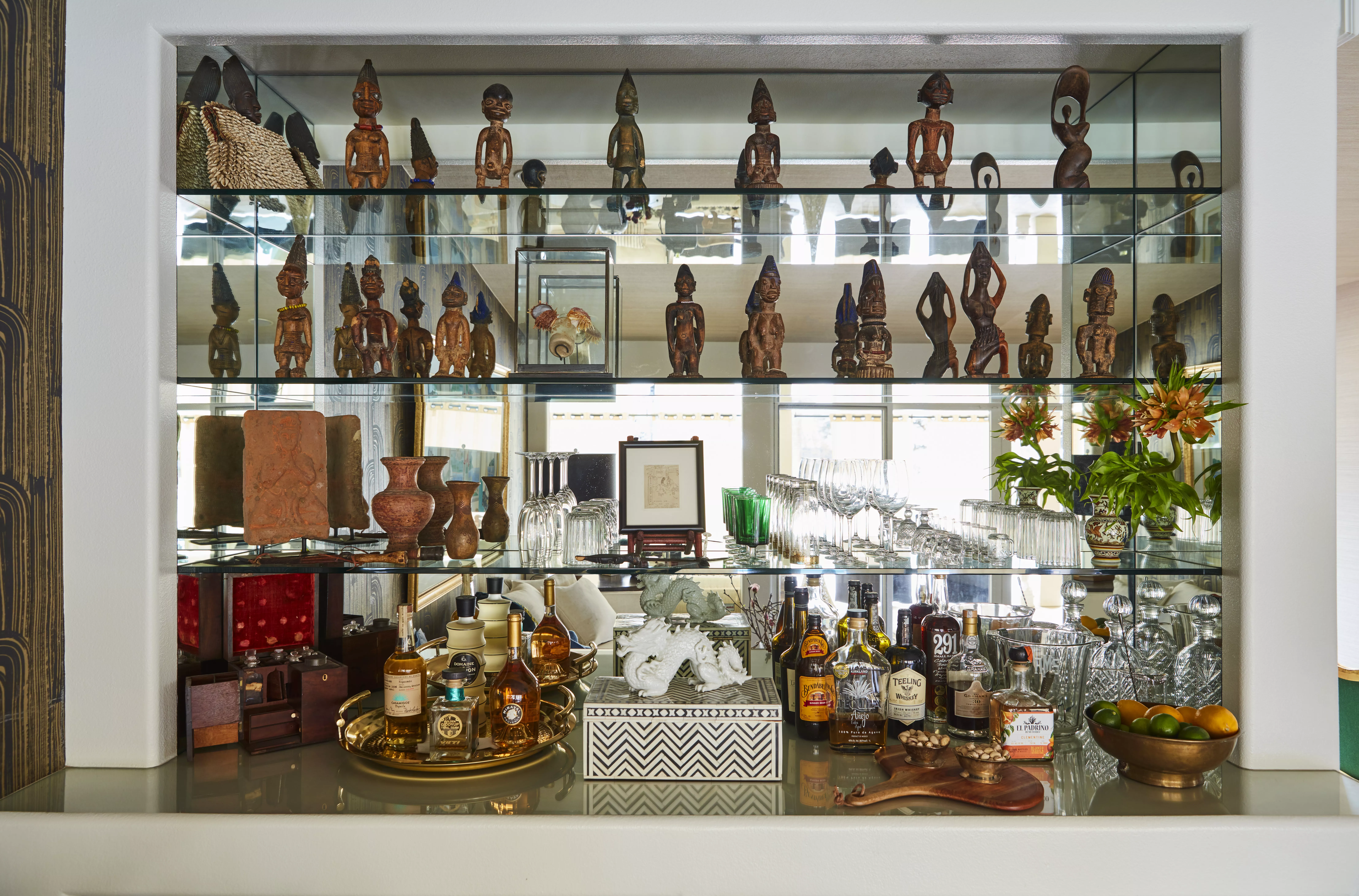 In home glass bar shelves with tribal decor and unique accessories