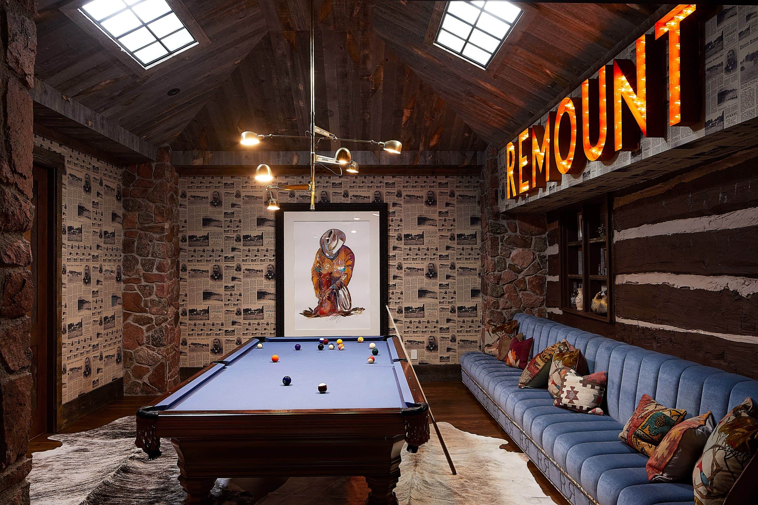 Modern ranch billiards room with custom wallpaper and vintage sign.