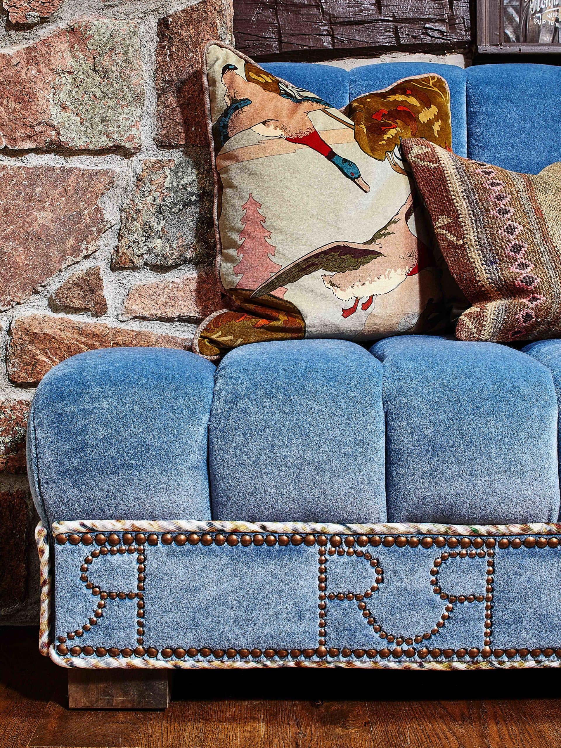 Custom upholstered sofas with Remount Ranch nail head designs and patterned throw pillows