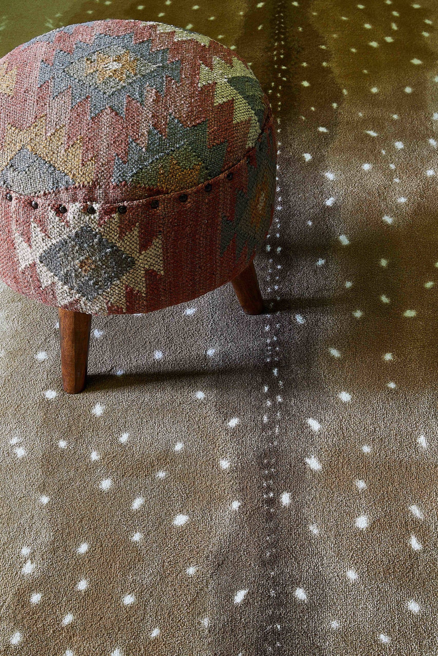 Doe pattern carpet with an antique stool.