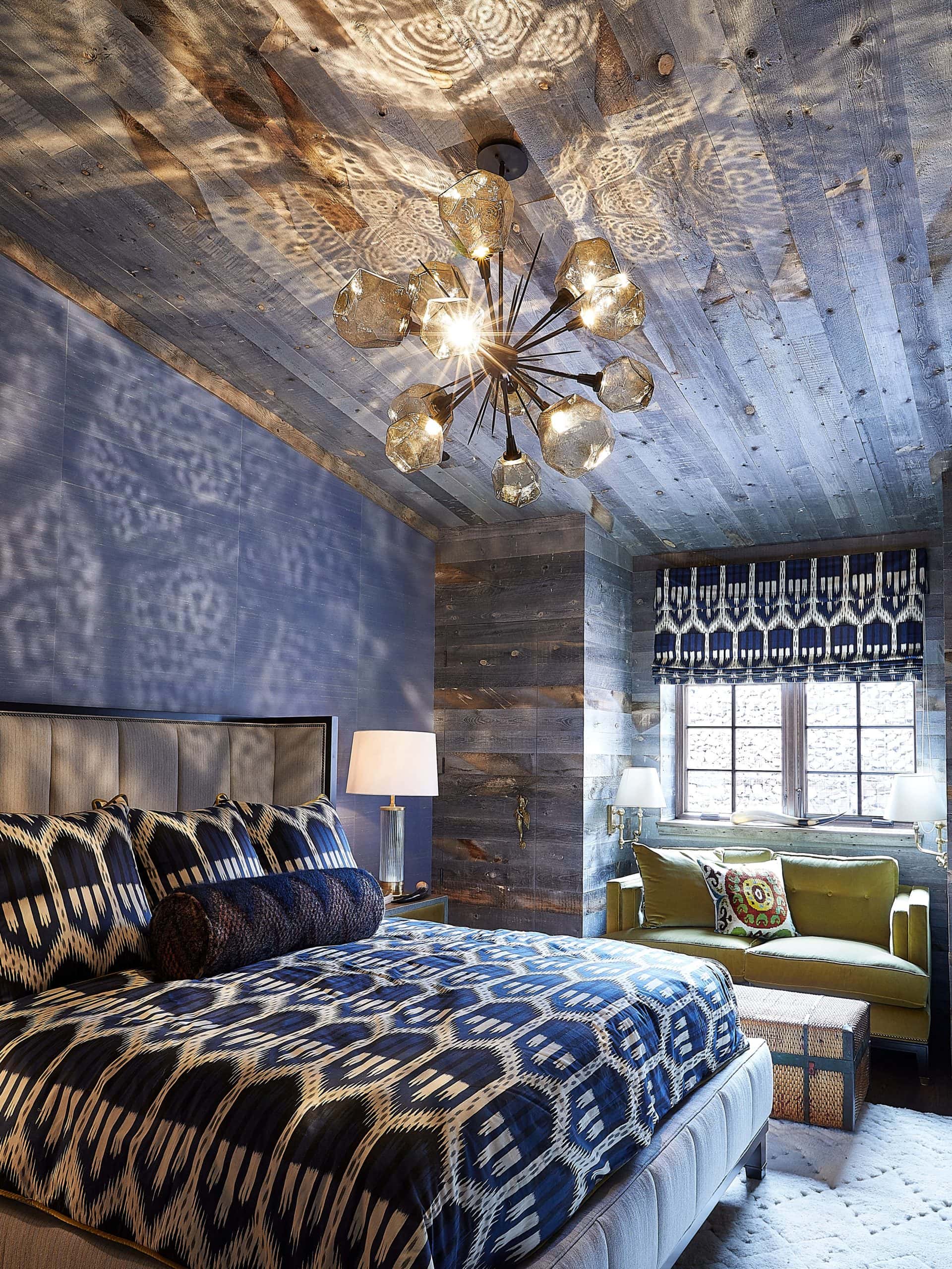 Geometric globe sputnik chandelier lit up and refracting on barn wood covered ceiling in master bedroom