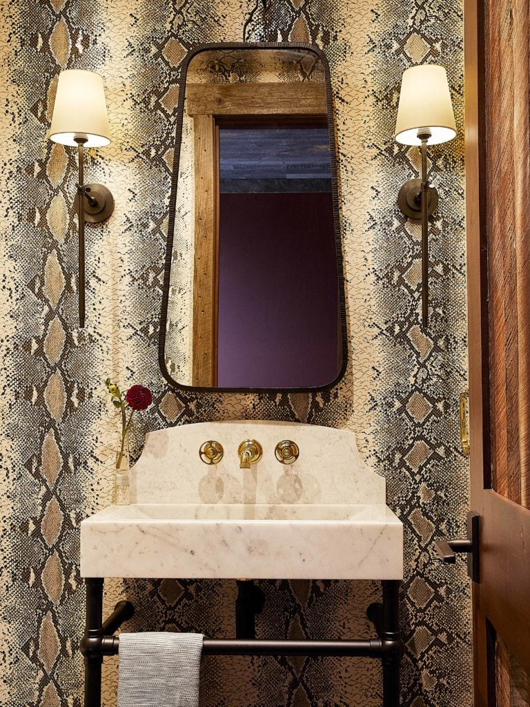 Powder room with bold snake print wallpaper by Colorado interior designers