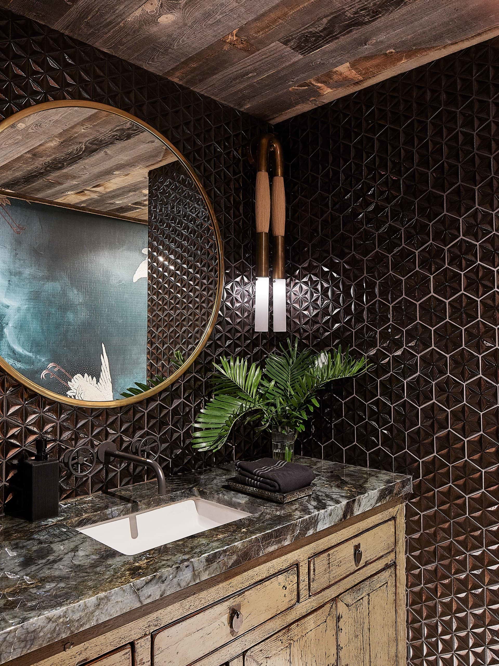 Powder bath with black hexagon tile and brass mirror. Refurbished antique Asian cabinet vanity.