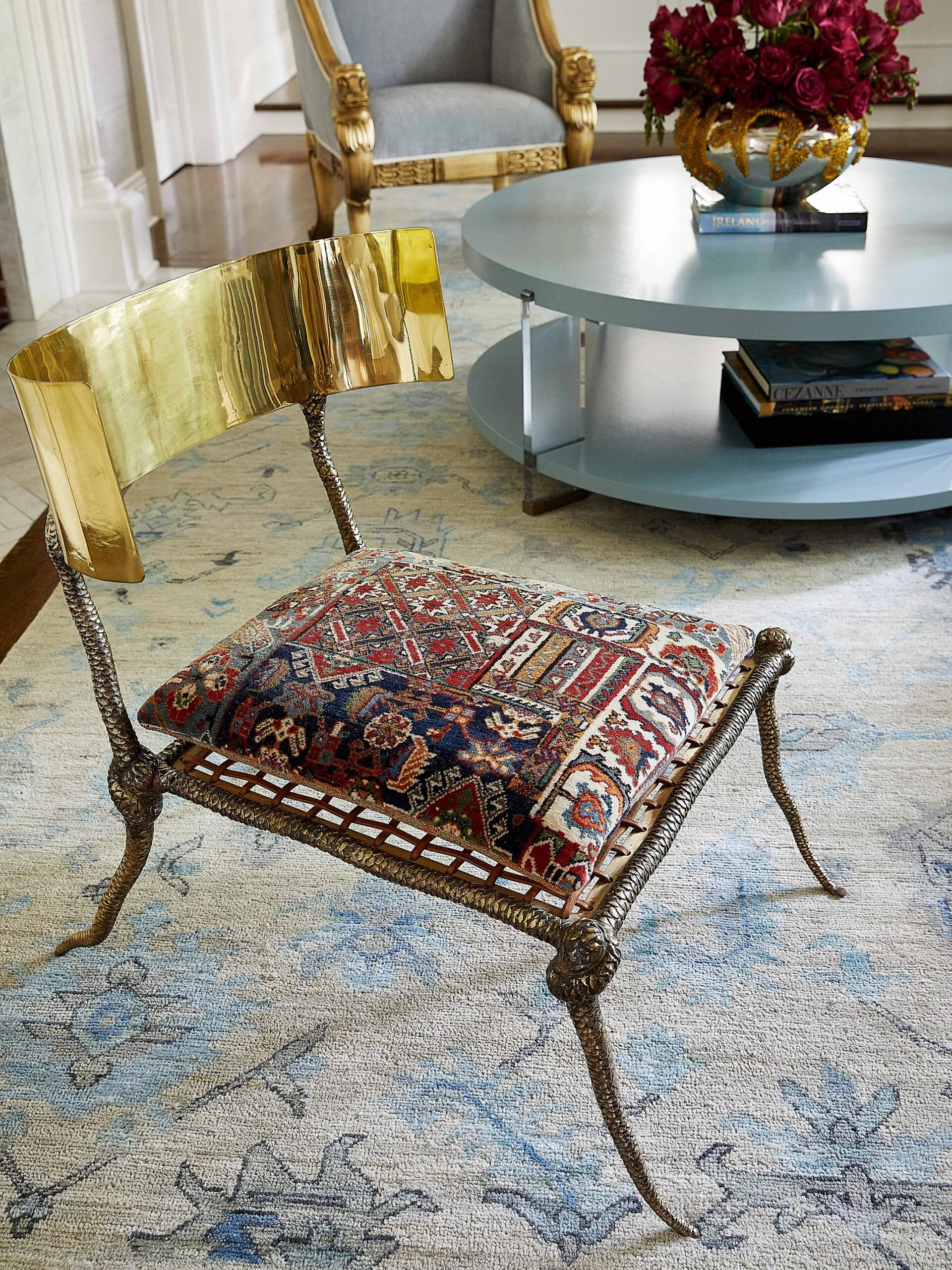Antique brass chair with snake legs and vintage cushion