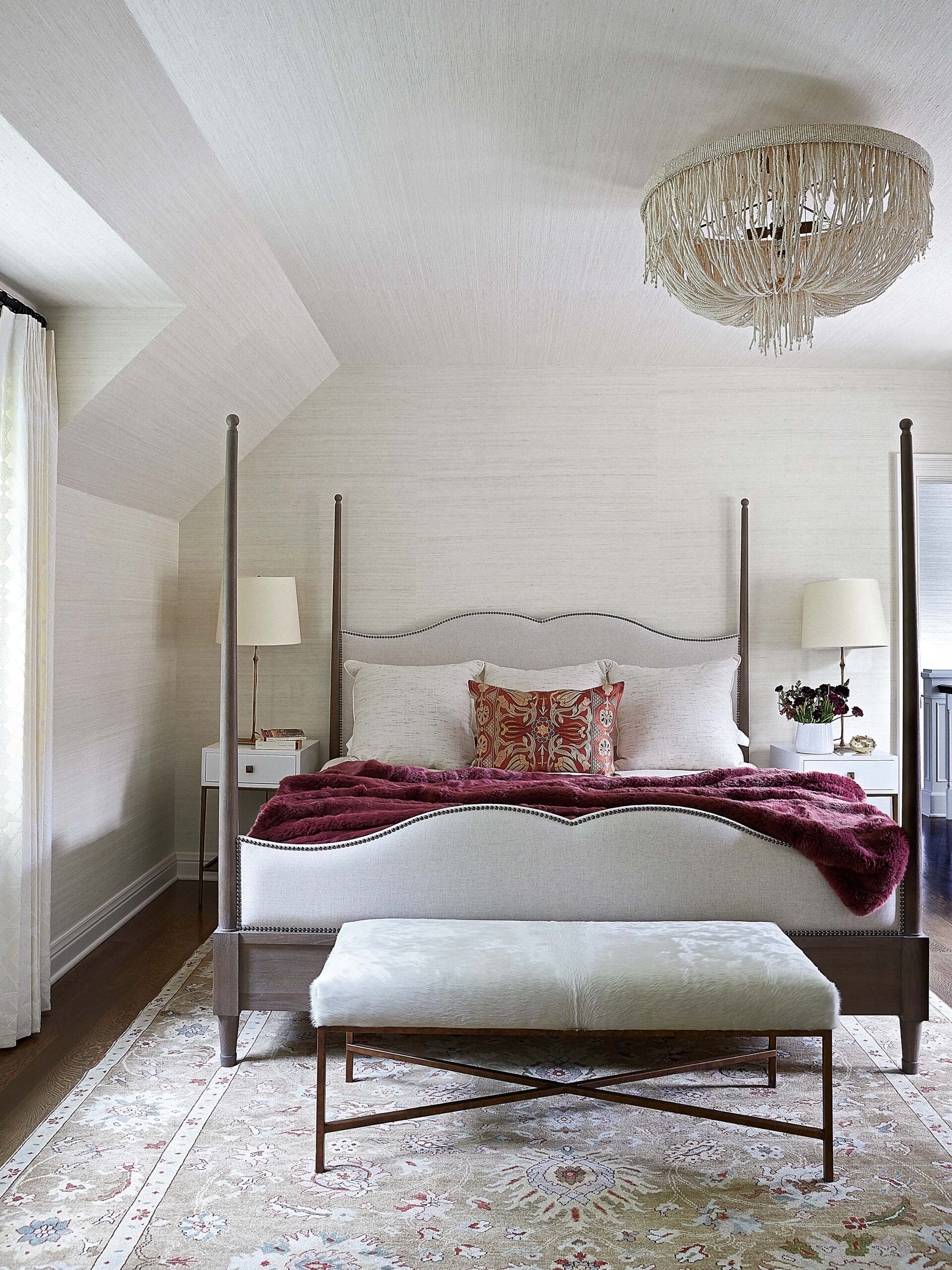 Four post bed with purple throw in primary bedroom