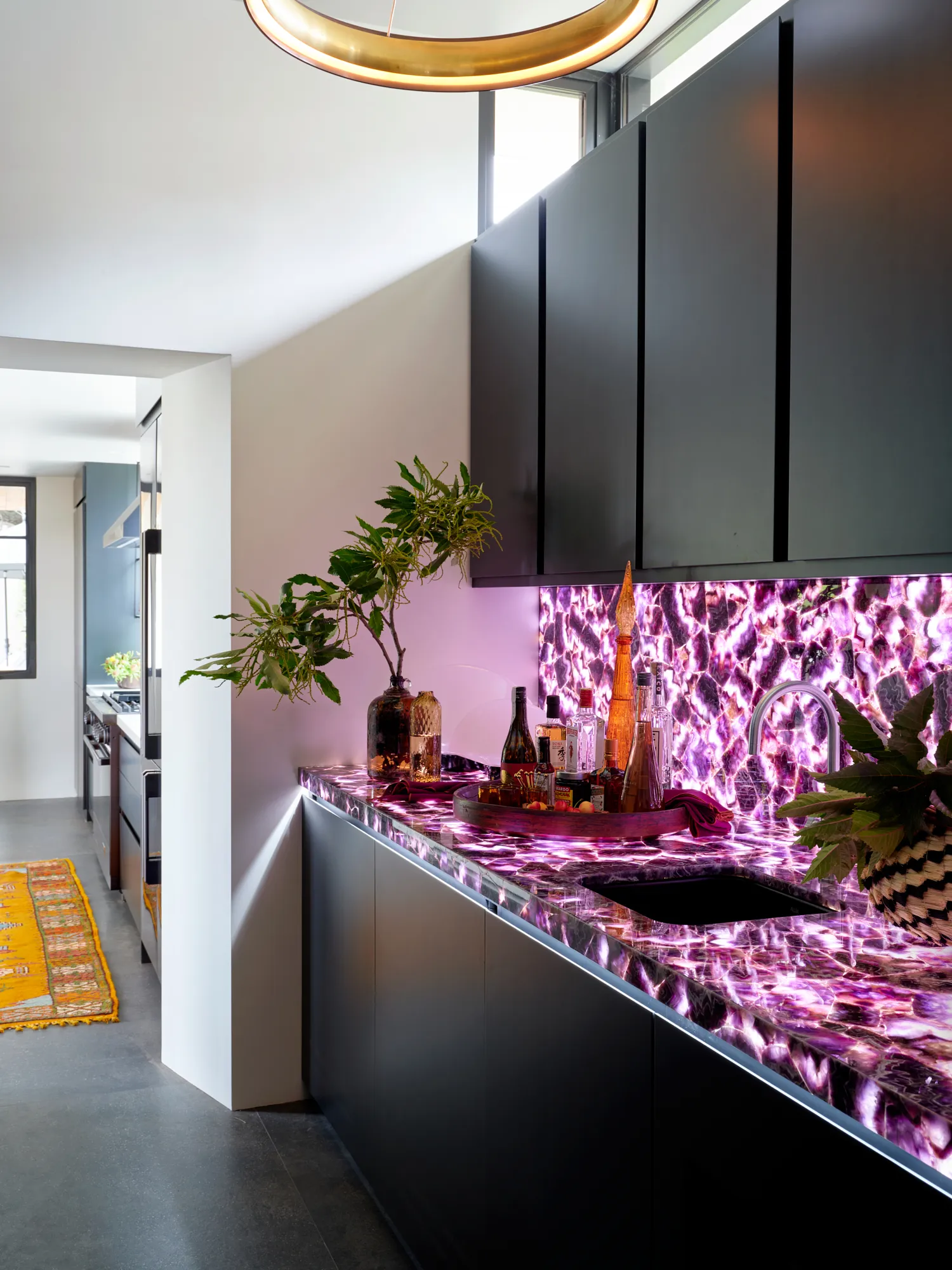 Contemporary powder room with illuminated pink stone vanity and moody lighting