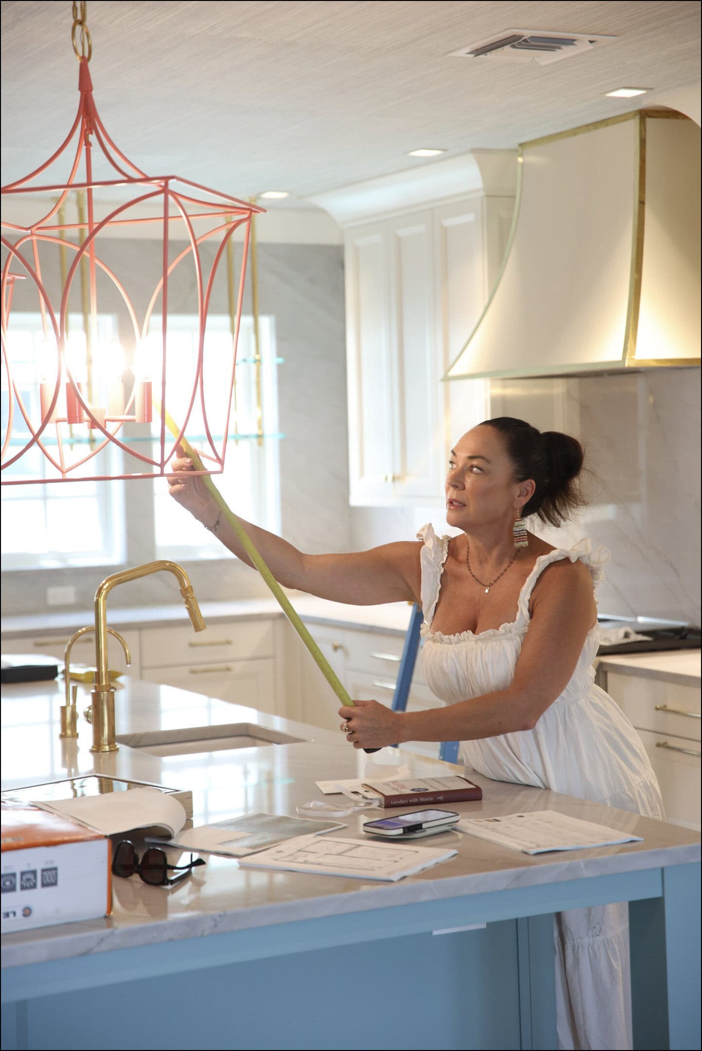 Andrea Schumacher measuring a pendant light during a Boca Grande, Florida vacation home installation
